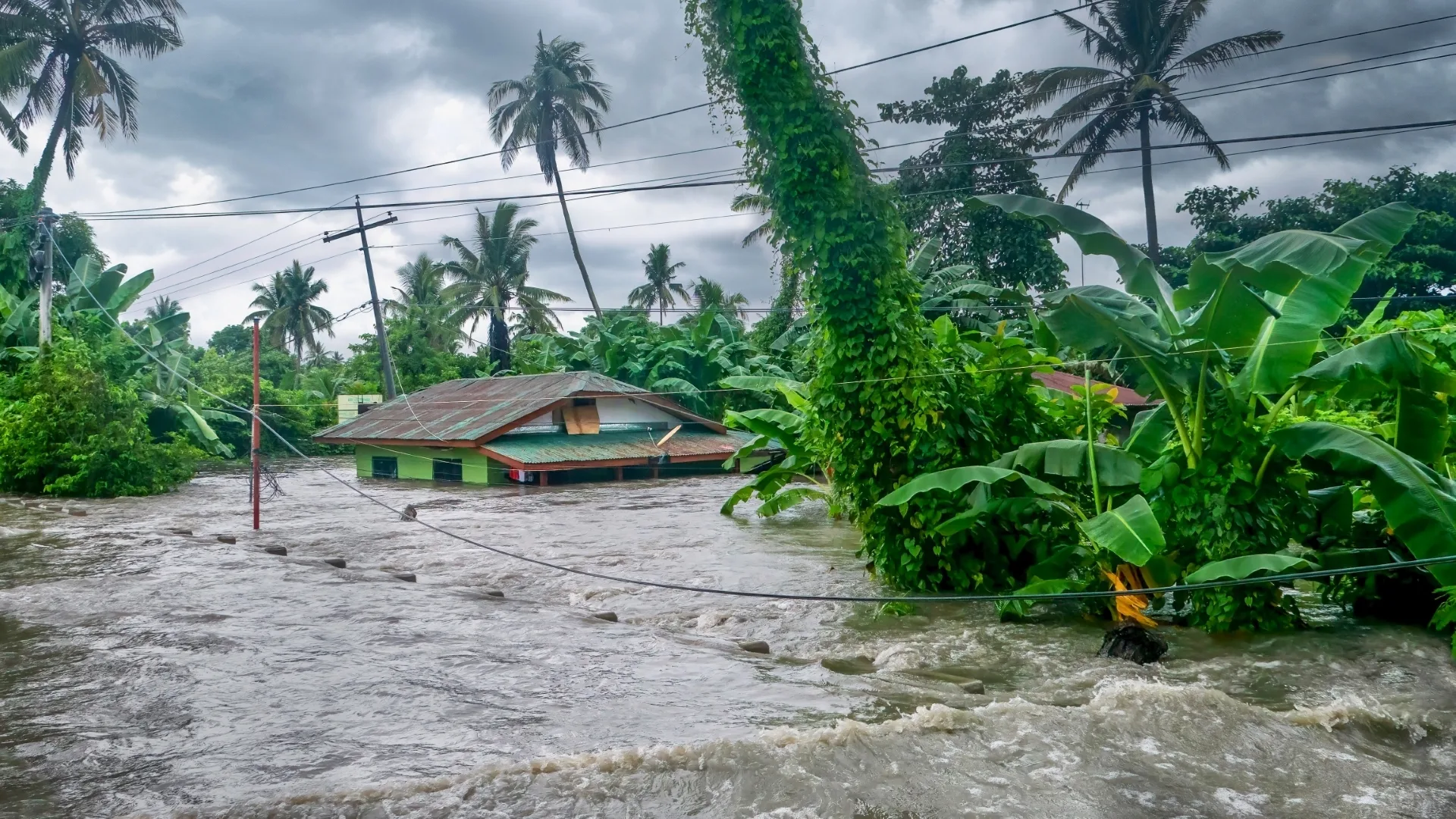 Rising water levels submerging a house as heavy monsoon rains ca